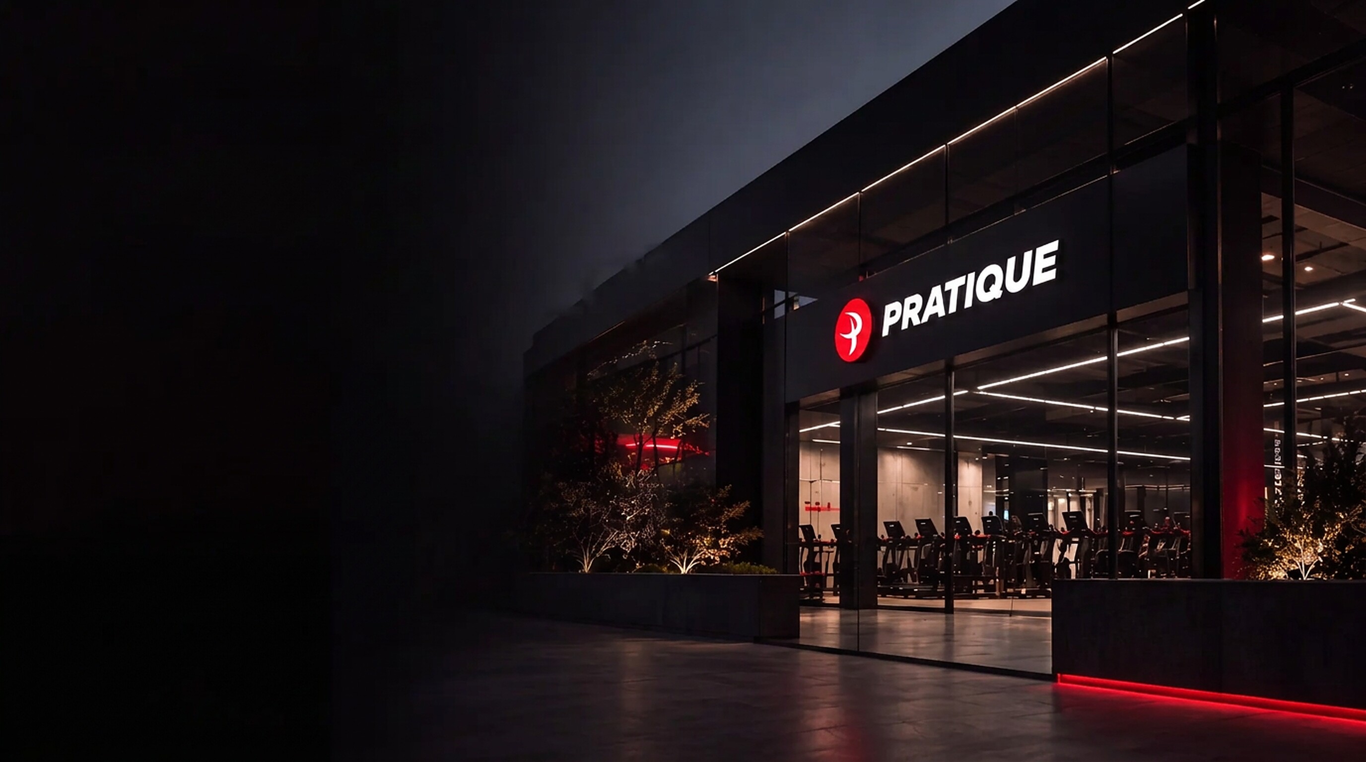 Fachada iluminada de un gimnasio Pratique al atardecer